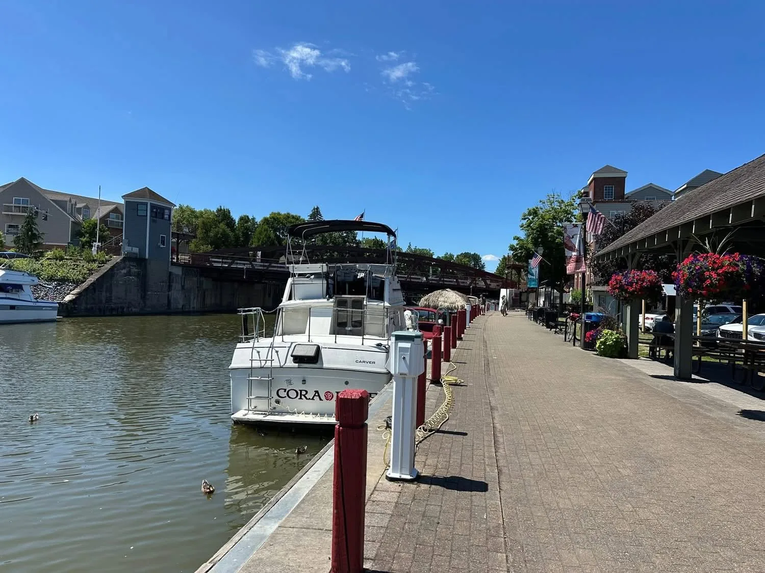 The canal path outside on a clear day, with a boat tied up and the bridge beyond